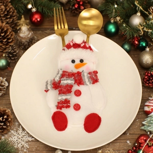 Snowman Christmas cutlery holder set on white plate with pine cone festive decor