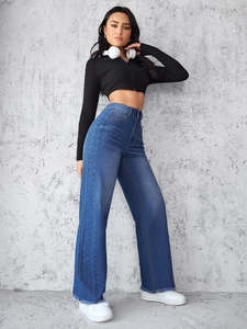 Detailopname van een high-waist jeans met wijde pijpen en distressed zoomtextuur