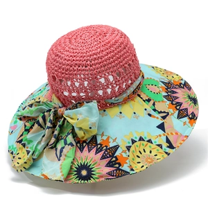 Close-up of summer sun hat with pink straw crown and colorful geometric print brim