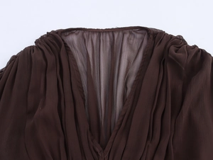 Detail of elegant V-neckline with gathered pleats on sheer dark brown bohemian maxi dress