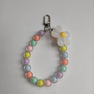 Detail of macaron color acrylic beads and white resin flower with silver spring clasp