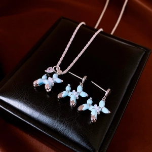 Gros plan sur le collier et boucles d'oreilles chien ballon bleu clair avec perles