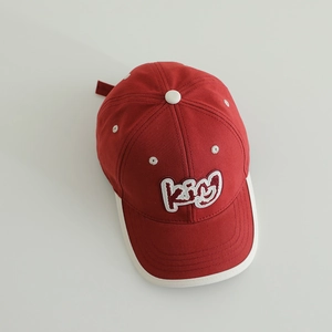 Detailed close-up of red kids baseball cap with King 3D embroidery and white piping edges