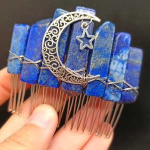 Handcrafted lapis lazuli hair comb with silver moon and star charms held in hand