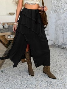 Detail of high-waist lace-up closure and ruffled layers on a black midi skirt