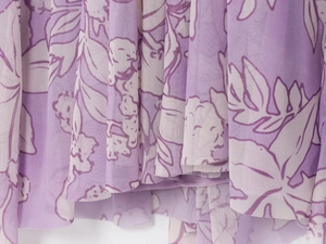 Detailed view of the sheer mesh fabric featuring a purple floral print and elegant drape
