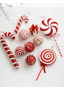 Flat lay of red and white Christmas candy cane ornaments with glitter and ribbon detail