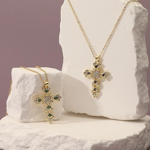 Baroque gold cross necklaces with zircon stones on white stone, professional jewelry shot
