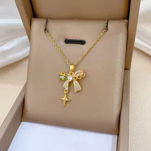 Detail of gold necklace with butterfly pendant and star charm on luxury display