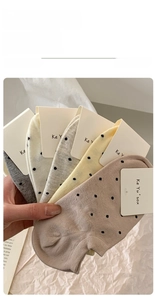 Close-up of five pairs of polka dot cotton no-show socks in soft neutral tones