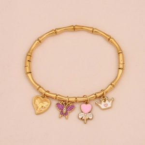 Bracciale a polsino in bambù dorato con ciondoli farfalla, cuore e corona su rosa