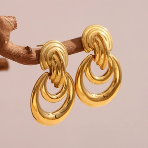 Détail de boucles d'oreilles double anneau plaquées or 18 carats sur une branche