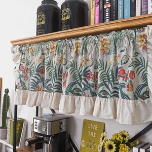 Floral cotton linen cafe curtain with beige ruffle trim hanging on a wooden shelf