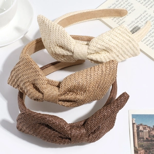 Three stylish straw woven bow headbands in beige and brown colors for a retro casual look