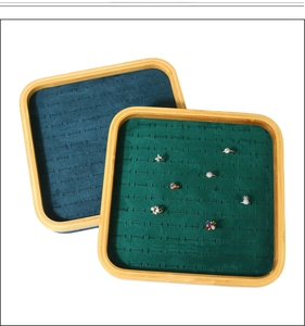 Detail of bamboo jewelry tray with green velvet lining for rings and studs display