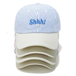 Stacked blue striped baseball caps with Shhh! embroidery and beige curved brim