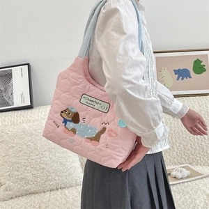 Detalle del bolso tote acolchado rosa con bordado de perro y botón verde menta
