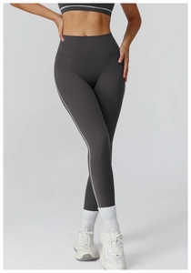 Detail of high waist charcoal grey yoga pants featuring side contrast white piping trim
