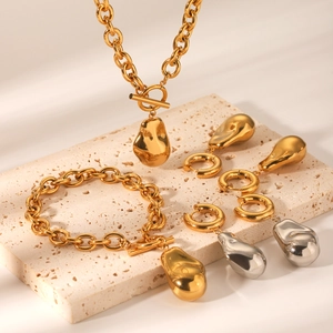 Vue détaillée d'un ensemble de bijoux or et argent avec pendentifs gouttes sur pierre