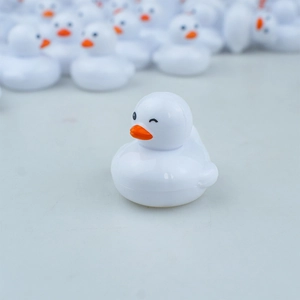 Macro shot of realistic white duckling toy with winking eye detail and orange beak