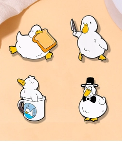 Set of four cute white duck enamel pins with creative knife and toast designs