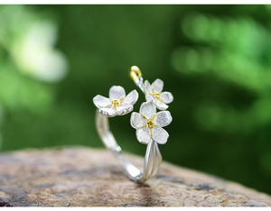 Detail view of S925 sterling silver forget-me-not flower ring on natural stone background