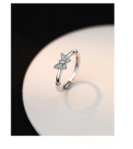 Detailed close-up of a S925 sterling silver butterfly ring with luminous wings and a gem