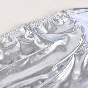Macro detail of silver metallic reflective fabric with elastic hem and textured finish