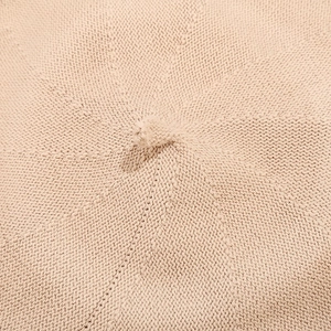 Close-up of the fine knitted texture and central button detail on a pink beret hat
