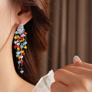 Detail of silver needle rhinstone earrings with colorful beads on cascading tassels