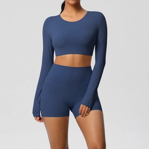 Detailopname van crop top met lange mouwen en sportshort met hoge taille en zijzakken in blauw