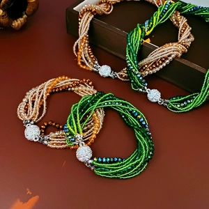 Gros plan de bracelets multicouches en perles de cristal avec fermoirs magnétiques vert et ambre