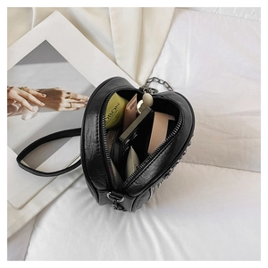 Interior view of heart-shaped leather crossbody bag showing storage for phone and makeup