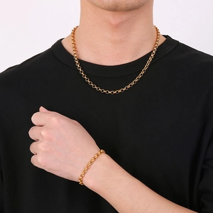 Minimalist gold rolo chain necklace and bracelet set for men and women on black shirt