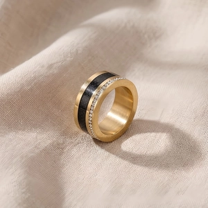 Close-up of gold titanium ring with black matte inlay and pavé set white crystals
