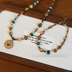 Détail de bijoux bohèmes vintage avec pierres d'œil de tigre et pendentif soleil