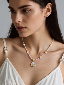 Détail du collier de perles avec pendentif triangle en émail bleu style océan sur mannequin