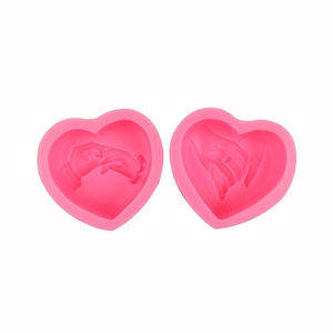 Pink heart-shaped 3D silicone mold featuring detailed holding hands for DIY candle making
