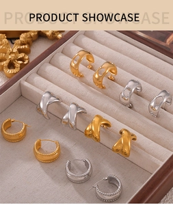 Détail d'une collection de boucles d'oreilles dorées et argentées en boîte à bijoux