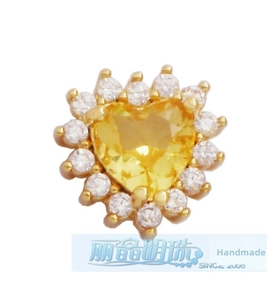 Macro detail of gold-plated heart pendant with yellow zircon and white halo crystals
