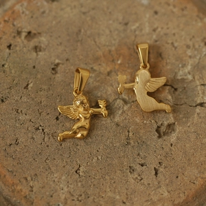 Detailed macro view of two golden Cupid angel pendants with polished and matte finishes