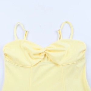 Detailed view of pale yellow mini dress with adjustable straps and pleated neckline