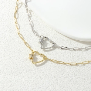 Macro shot of gold and silver heart carabiner necklace with micro-inlaid zircons