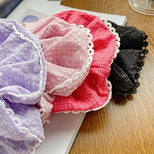 Set of four lace-edged fabric scrunchies in purple, pink, red and black colors