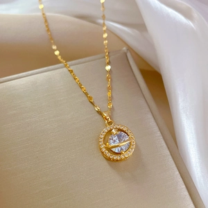 Macro detail of gold planet necklace with zircon inlay on luxurious white silk background