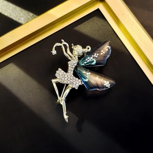 Macro detail of ballerina brooch featuring crystal rhinestones and blue gradient wings