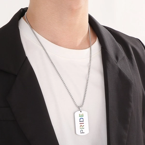 Close-up of a stainless steel military tag necklace with rainbow Pride cutout on male model
