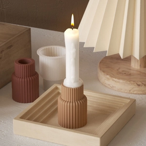 Macro view of terracotta striped candle holder and square tray in a home setting