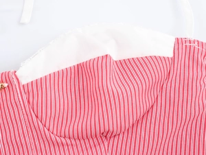Detailed close-up of red striped dress with lace trim and high-quality gold zipper head