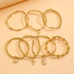 Detail of 8-piece gold beaded bracelet set with star, heart, and religious charms